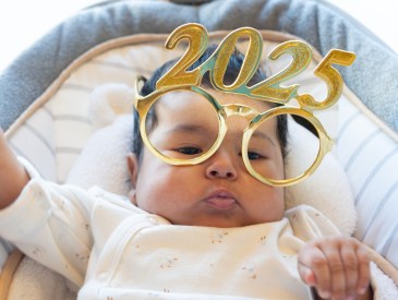 funny portrait of cute dancing baby celebrating with new year 2025 glasses. happy new year 2025 greeting. funny real photo postcard. copy space