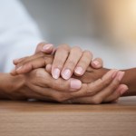 Hope, black woman or doctor holding hands in hospital consulting for medical test news or results for sympathy. Empathy, sad or zoom of nurse in healthcare clinic nursing or helping sick patient.