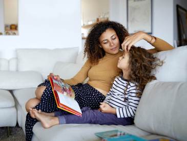 Mom reading to child on couch