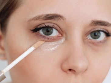 woman applying under-eye concealer
