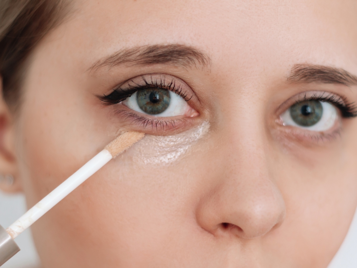 woman applying under-eye concealer
