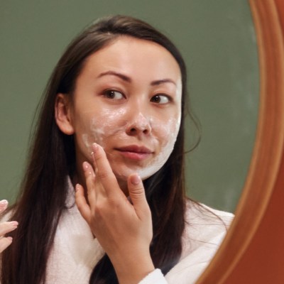 woman using face exfoliant