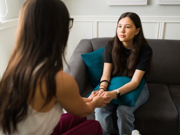 Therapist holding hands with a teen patient