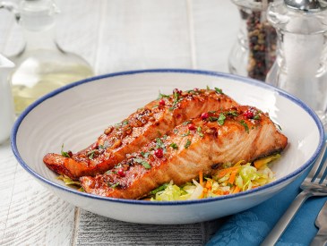 Honey garlic glazed salmon with vegetables in a white plate, white table. Healthy food concept.