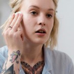 Woman in Blue Button Up Shirt Applying Make Up