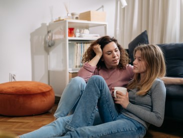 mother talking with her daughter sitting in living room