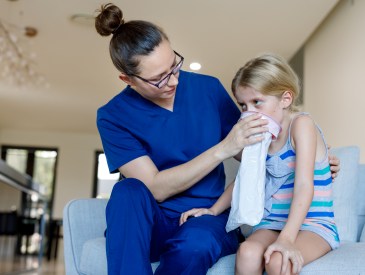 Home Call Nurse Using Sick Bag With Child in Australian house