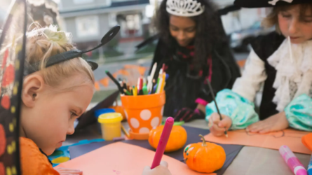 Kids in Halloween costumes coloring
